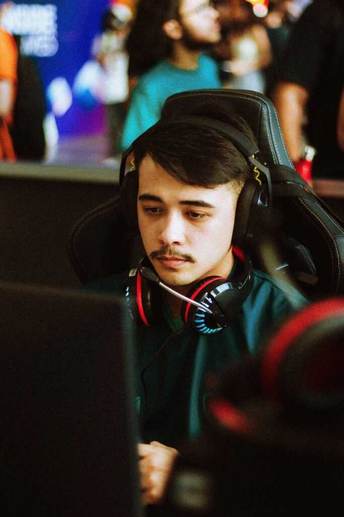 Young male gamer intensely focused at an esports tournament, wearing headphones.